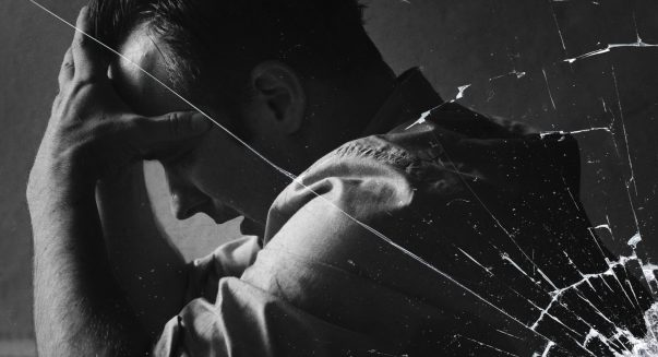 stressed-man-sitting-hopelessly-with-cracked-glass-effect-scaled.jpg