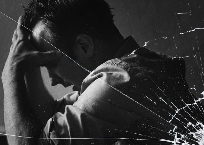 stressed-man-sitting-hopelessly-with-cracked-glass-effect-scaled.jpg
